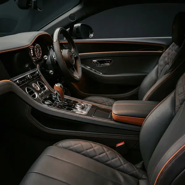 Habitacle de GT de luxe, sellerie cuir surpiquée et sélecteur usiné