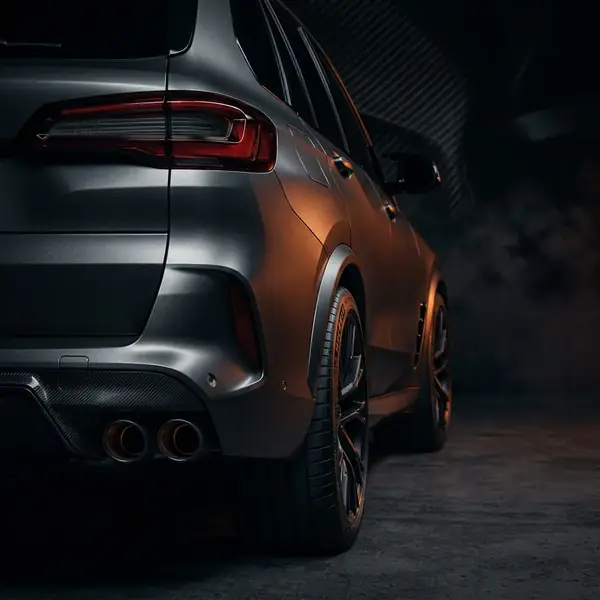 Détail arrière d'un SUV performant, sorties d'échappement quadruples et hanche musclée